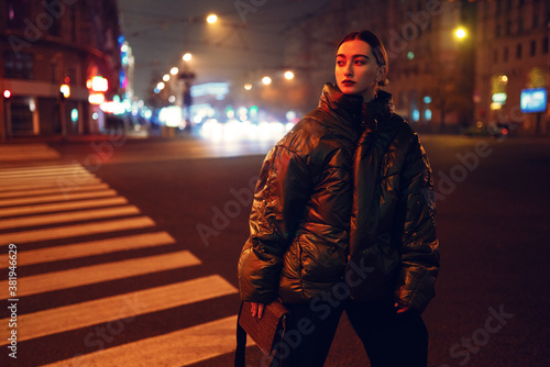Woman on crosswalk in red light at night