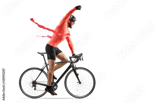 Male cyclist finishing a bicycle race at the finish line and gesturing win with hand