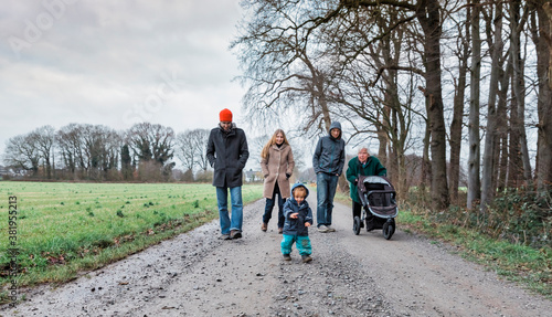 Multi-generational family walking on footpath