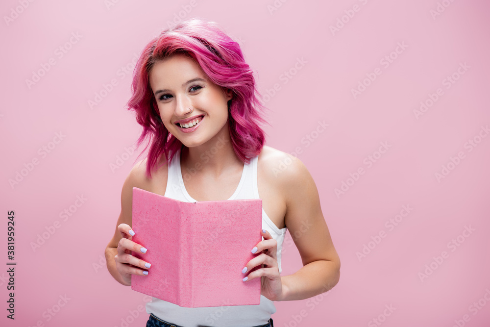 young woman with colorful hair holding open book isolated on pink young woman with colorful hair holding open book isolated on pink
