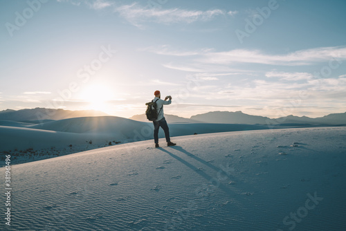 Anonymous male standing on sandy dune