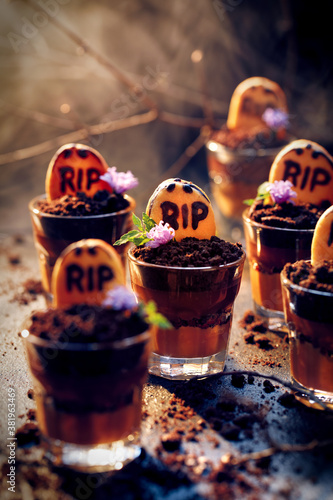 Halloween graveyard chocolate cups dessert with tombstone cookies, focus on the dessert inside. Halloween food idea for  party  photo