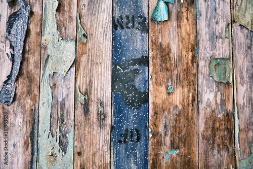 A characterful textured tabletop background with weathered and worn paint falling and flaking off wooden planks. Colourful paints used create a chaotic appearance.