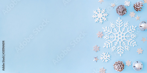 Flat lay border with christmas decorationon and snowflakes on a blue background photo