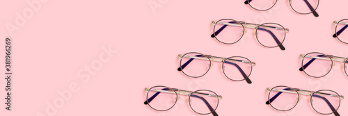 Frame made of eyeglasses layout on a pink pastel background. Creative banner with copy space.
