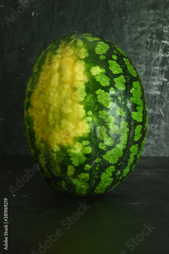 A whole big watermelon on a black table background