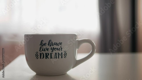 A Cup of steaming drink. Inscription Be Brave Live Your Dream, Motivational text