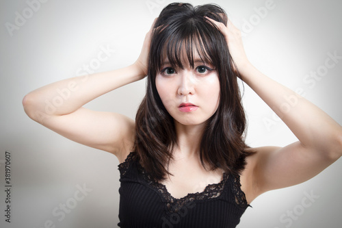 何かに困って髪を乱している日本人の女性