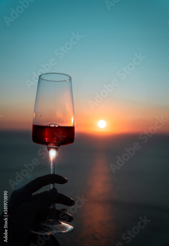 a glass of wine by the sea at sunset