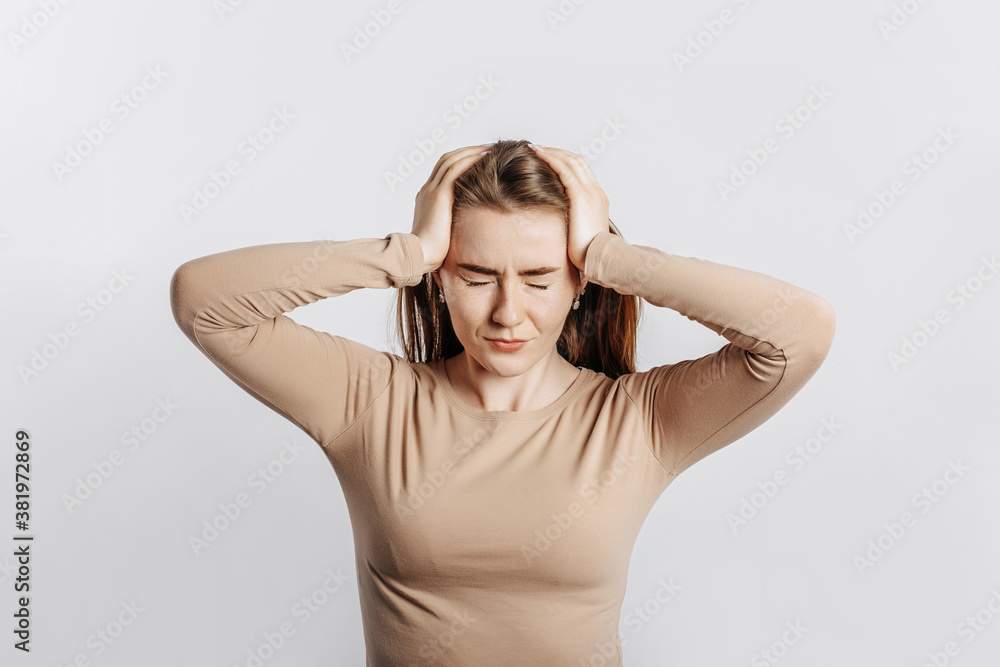Beautiful young girl posing looking at the camera on a white isolated background. Serious brunette woman ignores covers her ears with her hands and closes her eyes, does not see and does not hear Beautiful young girl posing looking at the camera on a white isolated background. Serious brunette woman ignores covers her ears with her hands and closes her eyes, does not see and does not hear