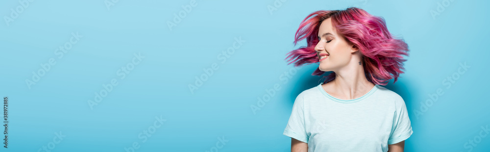 young woman waving pink hair on blue background, panoramic shot young woman waving pink hair on blue background, panoramic shot