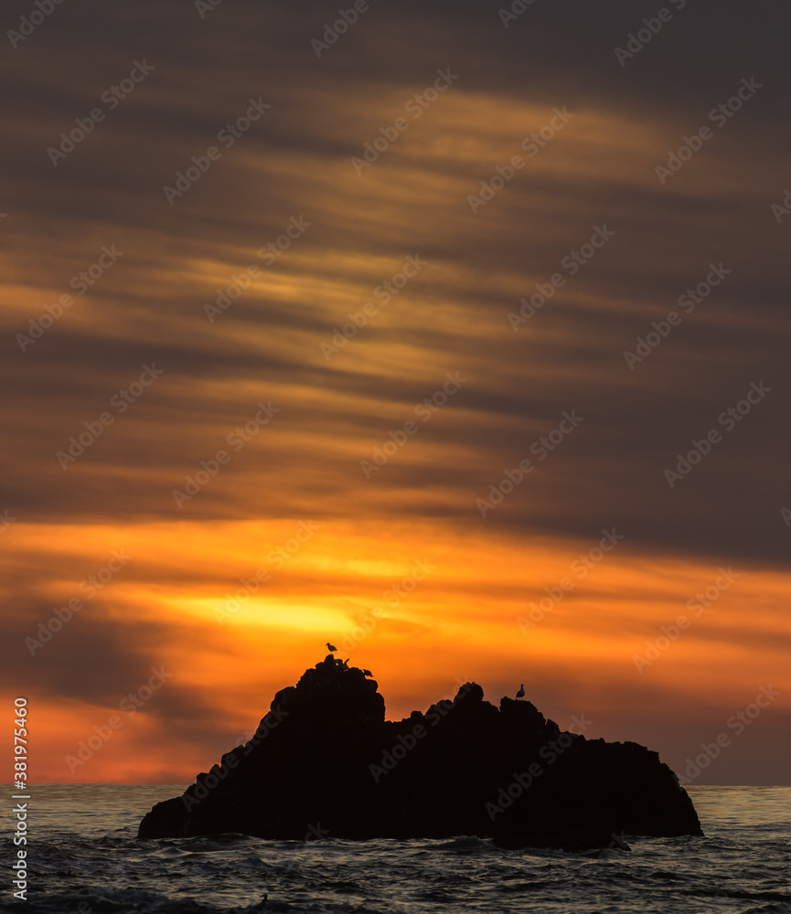A rock outcropping at sunset, just off shore from the beach at Canon Beach on the north Oregon coast.