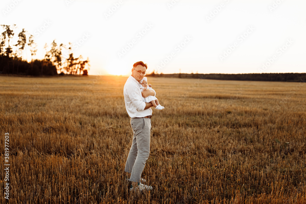 Caring father with adorable little daughter walking at the field, happy dad hold cute newborn baby girl in arms, tender family moments, parenting and fatherhood concept Caring father with adorable little daughter walking at the field, happy dad hold cute newborn baby girl in arms, tender family moments, parenting and fatherhood concept