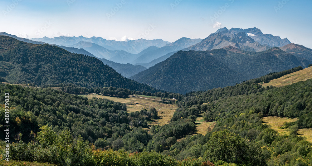 Panorama of Abkhazia valley at Caucasian mountain ridge background with Acetuka and Pshegishkha peaks at sunny summer day.