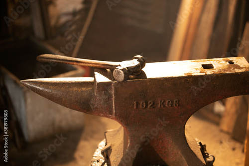 Hammer and anvil in blacksmith shop photo