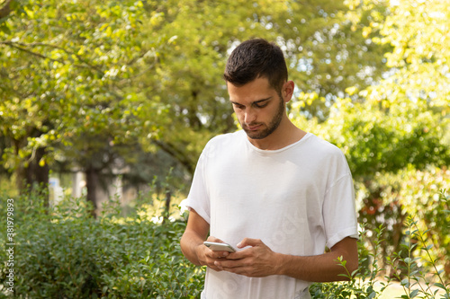 attractive young man with mobile phone outdoors