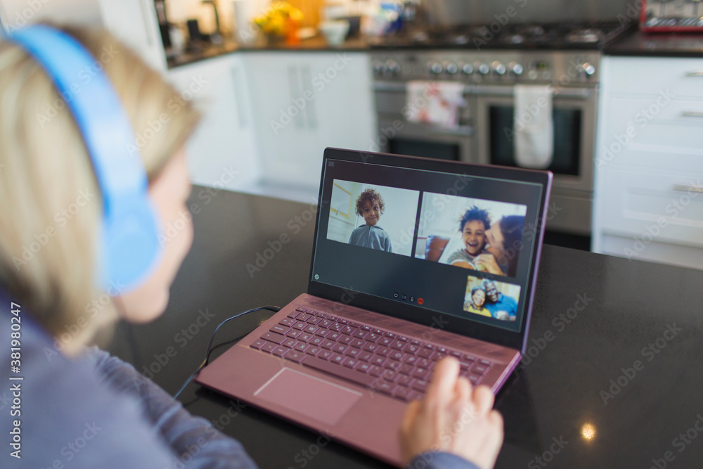 Woman with headphones and laptop video chatting with friends Woman with headphones and laptop video chatting with friends