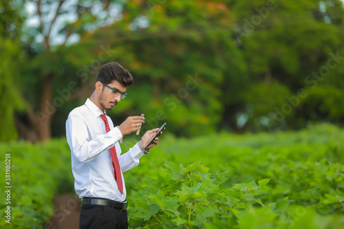 young indian handsome agronomist with test tube and tablet
