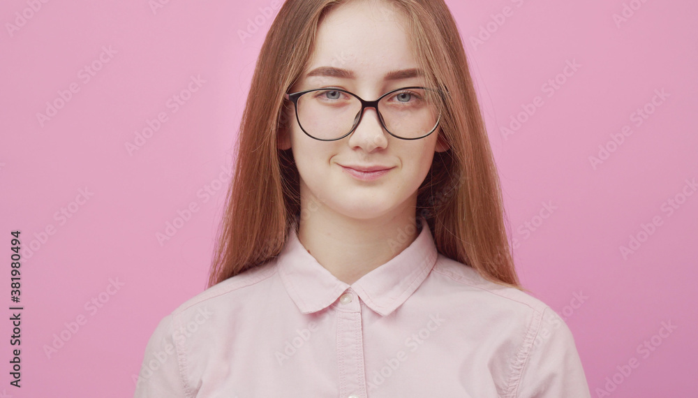 Headshot of young positive lady in eyewear and blouse looking at camera, isolated pink background