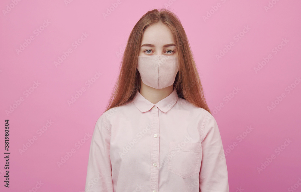 Portrait of young female wearing face mask looking at camera isolated on pink background Portrait of young female wearing face mask looking at camera isolated on pink background