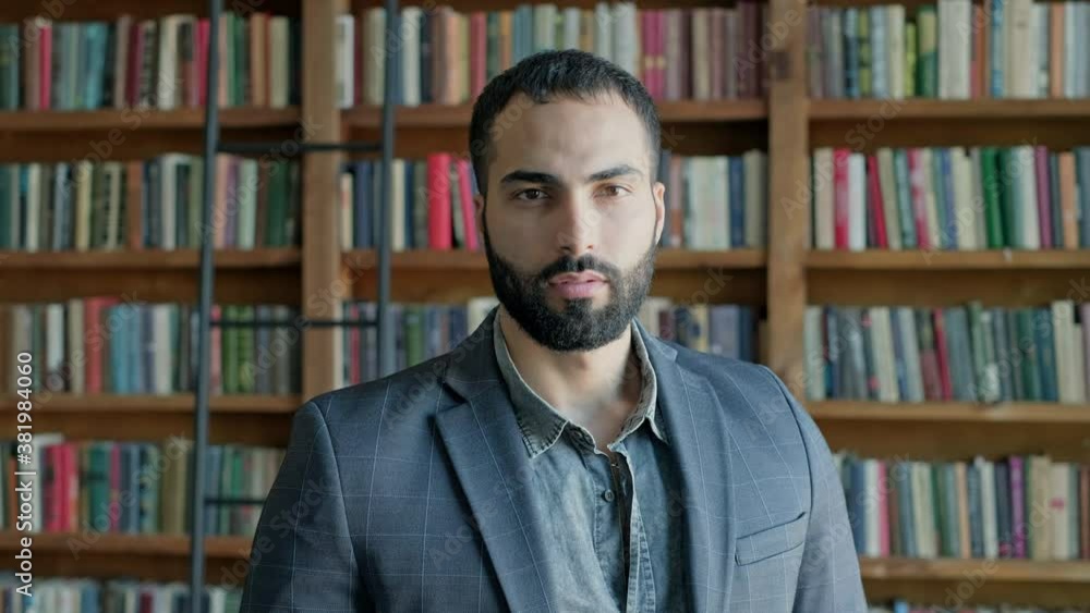 Guy Is Standing In The Library. Attractive Brunette With Beard From The Middle East. Guy Is Standing In The Library. Attractive Brunette With Beard From The Middle East.