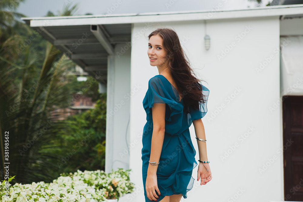 young stylish beautiful woman in blue dress, summer fashion trend, vacation, garden, tropical hotel terrace, smiling, walking young stylish beautiful woman in blue dress, summer fashion trend, vacation, garden, tropical hotel terrace, smiling, walking