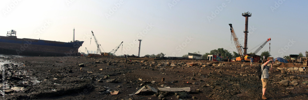 Shipbreaking Yard in Darukhana, Mumbai, India – INS Vikrant dismantling with scrap metal & workers in background