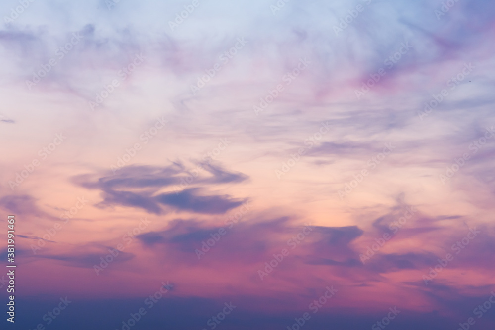 View of the sky in the evening at sunset with a dark cloud and a bright pink glow from the sun. Landscape concept, background.