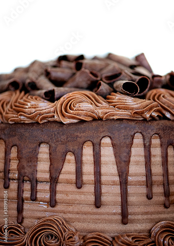 Close-up of Chocolate Cake Topped with Chocoloate Curls and Drizzled with Fudge Icing photo