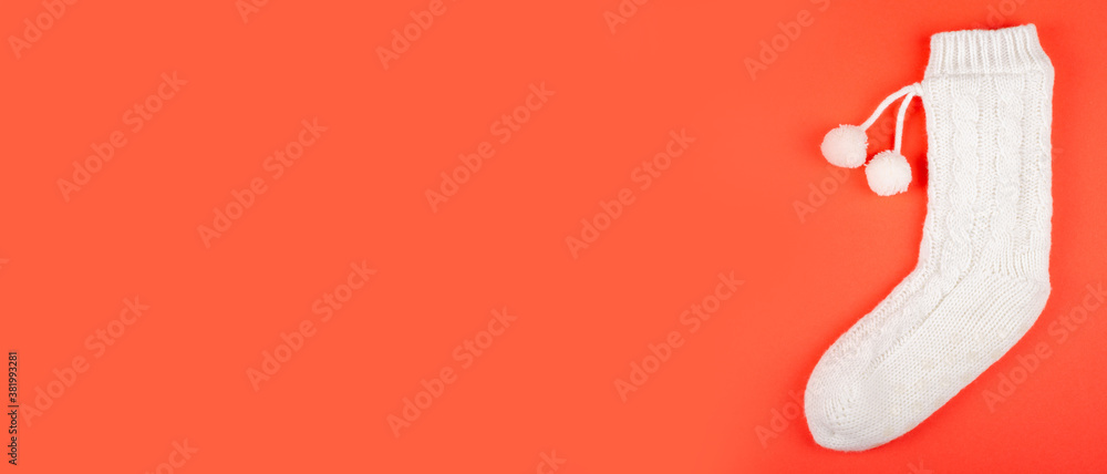 Obraz premium White socks with pom poms on red background composition. Flat lay and top view photo with copy space.