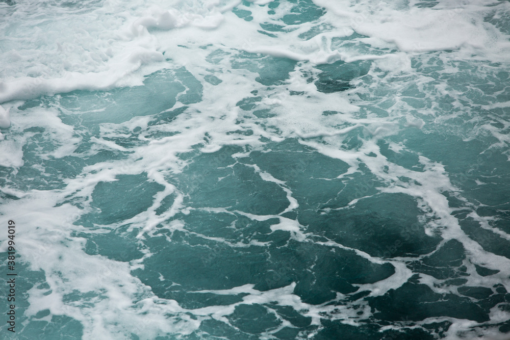 Waves and white foam at the sea. Watching the blue water building pattern. Waves and white foam at the sea. Watching the blue water building pattern.