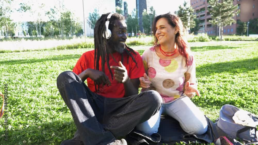 Man with dreadlocks and woman sitting on lawn Man with dreadlocks and woman sitting on lawn