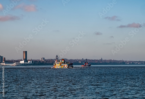 Liverpool, UK. Beautiful colorful long exposure shot of river Mersey from Albert Dock with smooth reflections of night lights from the other side of a shore and a boat. 