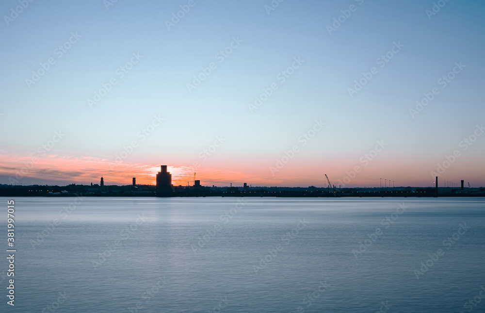 Liverpool, UK. Beautiful colorful long exposure shot of river Mersey from Albert Dock with smooth reflections of night lights from the other side of a shore. 