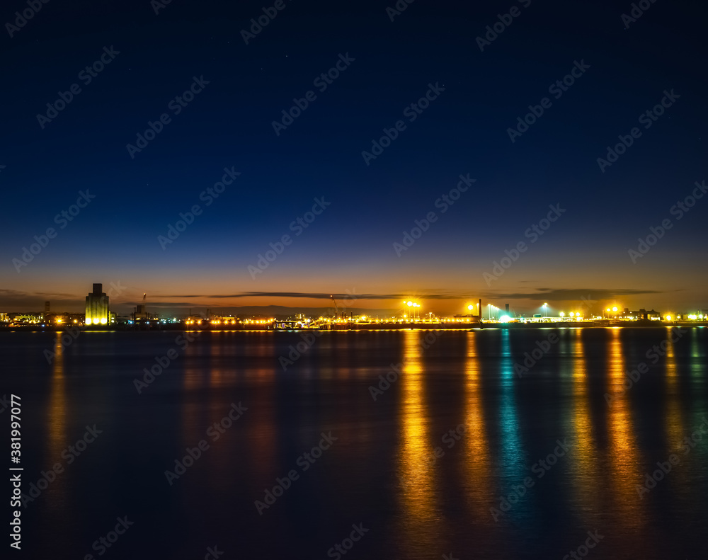 Liverpool, UK. Beautiful colorful long exposure shot of river Mersey from Albert Dock with smooth reflections of night lights from the other side of a shore. 