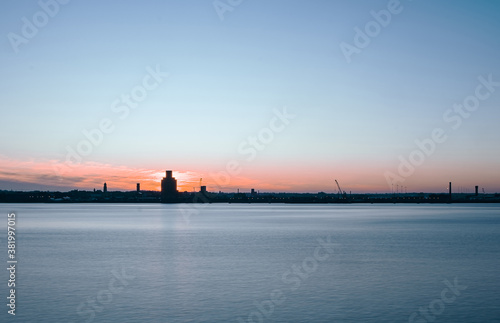 Liverpool, UK. Beautiful colorful long exposure shot of river Mersey from Albert Dock with smooth reflections of night lights from the other side of a shore. 