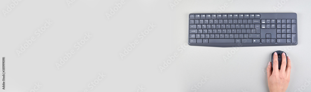 Hand with keyboard and mouse on grey background. Flat lay, overhead view image. Copy space, template. Hand with keyboard and mouse on grey background. Flat lay, overhead view image. Copy space, template.