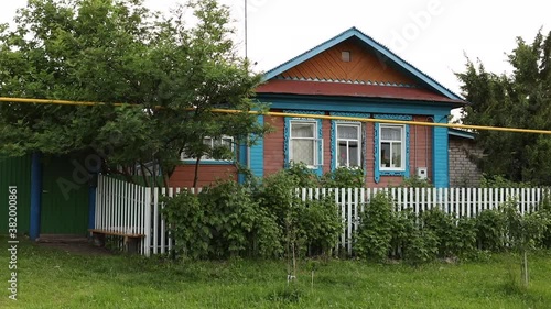 A middle age woman is walking through the street in the russian  village.