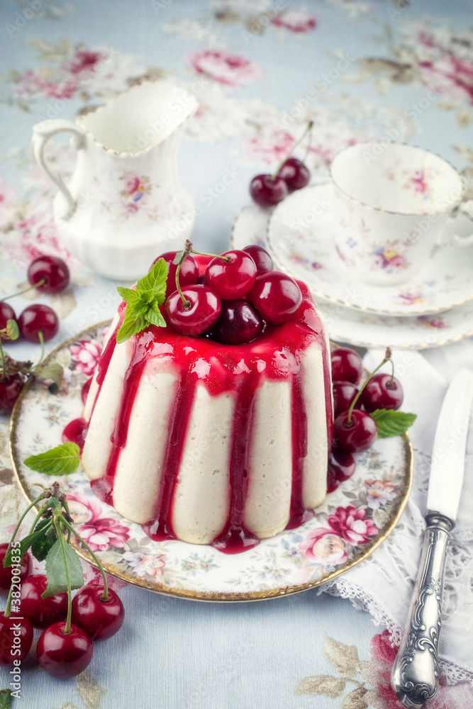 Traditional cherry cheesecake with fruits offered as close-up on design plate Traditional cherry cheesecake with fruits offered as close-up on design plate