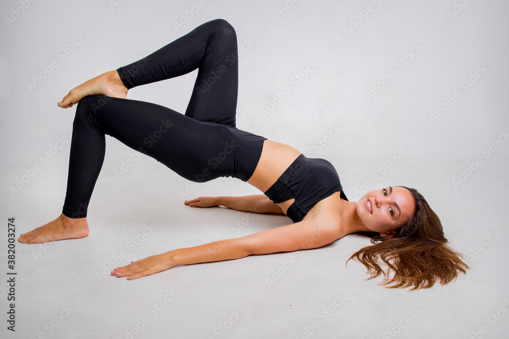 The brunette of an athletic physique goes in for sports in the studio on a white background.