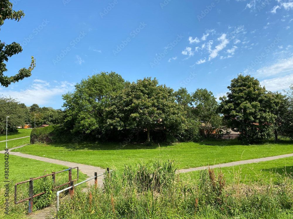 Small bridge, leading into a large field, with old trees, and footpaths, next to local houses near, Meanwood Road, Leeds, UK