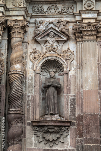 Quito, Ecuador - December 2, 2008: Historic downtown. Closeup of statue of male saint on Brown stone entrance facade to La Compania Church of the Jesuits.