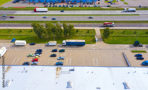Aerial view of warehouse with trucks. Industrial background. Logistics from above.