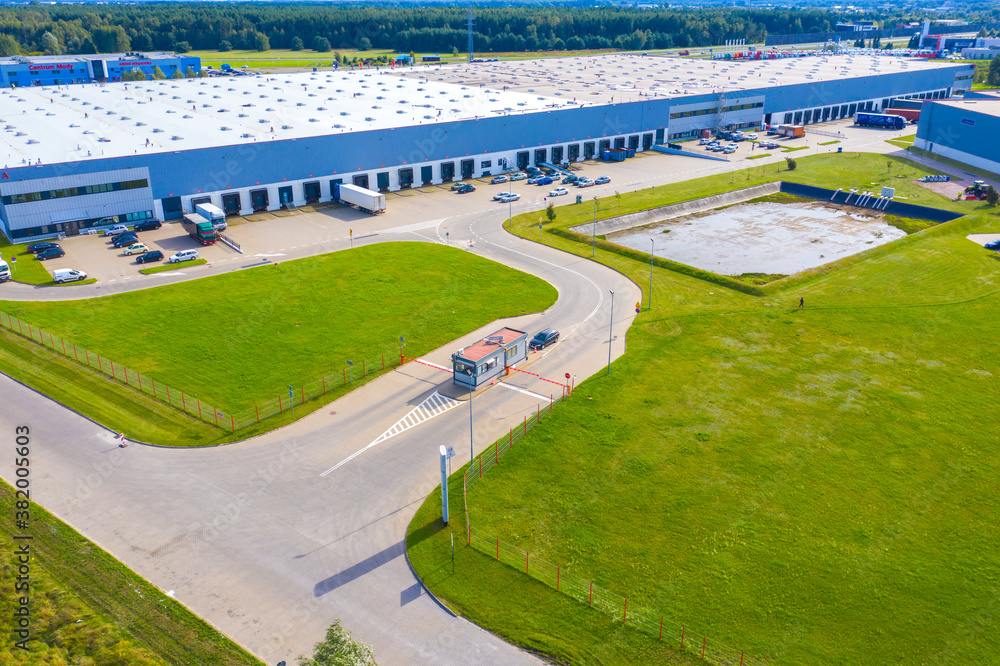 Naklejka premium Aerial Shot of Industrial Loading Area where Many Trucks Are Unloading Merchandise.