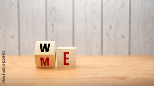 Obraz na płótnie cubes turning message ME to WE on wooden background