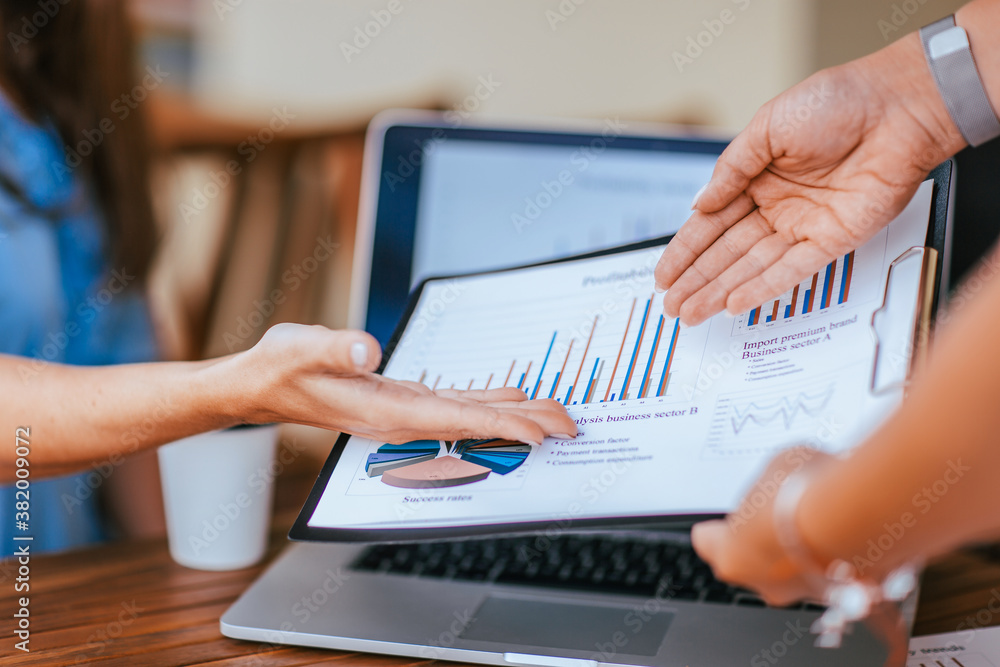 employees discussing financial data near the desktop. employees discussing financial data near the desktop.