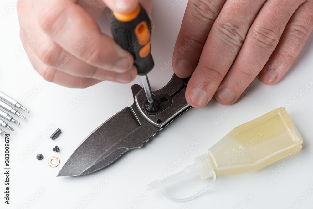 Close-up on repairman's hands assembling the parts of a pocket knife