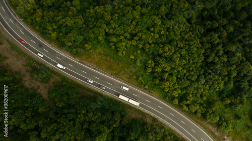 Bilde på lerret Aerial view over mountain road going through forest landscape