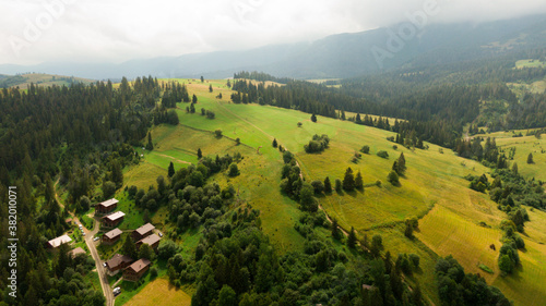 Tableau sur toile Mountain houses, with solar panels on the roof, through the pine forest in count