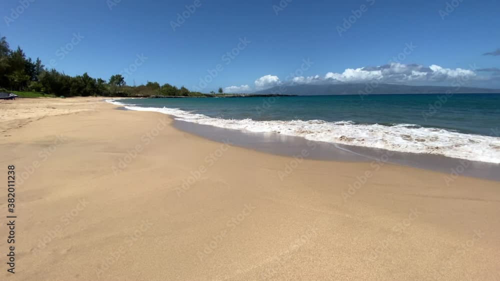 Mokulei'a Beach in Maui, Hawaii with gentle waves across golden sand Mokulei'a Beach in Maui, Hawaii with gentle waves across golden sand